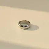 Anillo de banda ancha con diseño minimalista y acabado pulido brillante.
