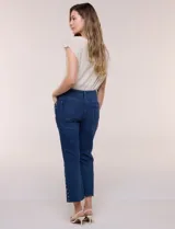 Jean crop de tiro alto, color azul, de pierna recta con terminación bootcut y detalles de tachas en los laterales.