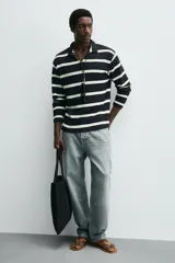 Bolso tipo shopper fabricado en cuero con acabado serraje color gris oscuro. Compartimento principal sin cierre con bolsillo interior con cremallera. Dos asas de mano fabricadas en cuero.