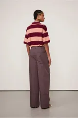 Pantalón de vestir de corte ancho, color borgoña con finas rayas verticales color beige. Presenta bolsillos laterales y traseros con botón.