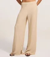 Pantalón texturizado marrón de corte ancho con cintura elástica y bolsillos laterales.