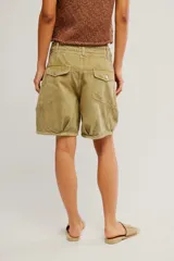 Short de sarga de algodón lavada verde militar, de tiro bajo, con silueta barrel, bolsillos y cierre frontal con botón.