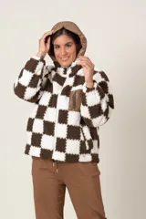 Campera símil corderito a cuadros marrones y blancos, con cierre frontal y bolsillos laterales. Capucha y bolsillo frontal con cierre de nylon color marrón.