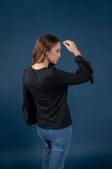 Blusa gris melange de punto tejido fino, con escote en V y mangas largas anchas terminadas en volados.