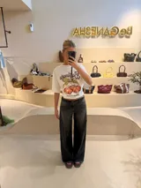 Pantalón de jean recto color gris oscuro, con efecto desgastado, recortes 360 y ajuste en cintura con presillas. Tiene tiro medio y detalles de bolsillos traseros con parches deshilachados.