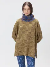 Pullover de punto jacquard color tostado con cuello alto y puños acanalados en tono azul y detalles en naranja. Cuenta con aberturas laterales y calce holgado.