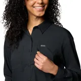 Camisa de senderismo Columbia de manga larga, color negro, con cuello clásico, cierre frontal con botones y múltiples bolsillos funcionales en el pecho. Presenta tecnología de protección solar y tejido transpirable de secado rápido.