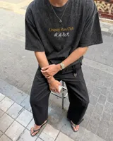 Remera marrón oversize con cuello redondo y mangas cortas. Estampado frontal con el texto "Uruguay Run Club" en celeste y siluetas blancas de personas corriendo.
