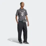 Camiseta de fútbol Adidas del Bayern Múnich, modelo Wiesn 24/25, para hombre. Diseño gris oscuro con patrón de rombos en relieve, cuello de polo con un botón y detalles en color crema/blanco roto. Presenta el logo del trébol de Adidas y el escudo del club bordado.