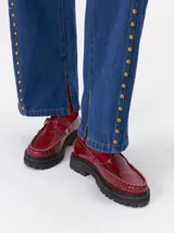 Zapato tipo guillermina de cuero color bordó, con diseño de mocasín, hebilla metálica y suela de goma con plataforma dentada.