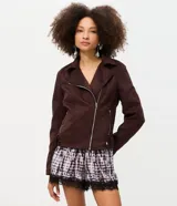 Campera tipo biker de gamuza sintética color marrón oscuro, con cierre diagonal de cremallera metálica, solapas amplias, bolsillos con cierre y trabillas ajustables en el bajo.