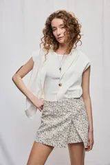 Short cruzado de tiro medio confeccionado en algodón, con diseño que imita una falda en el delantero. Presenta cierre lateral invisible y estampado floral sutil.