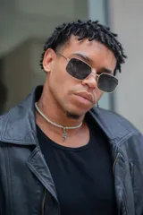 Lentes de sol con marco rectangular plateado y lentes grises.