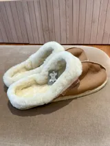 Pantuflas marrones confeccionadas en cuero lanar con suela de goma.