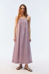 Vestido maxi amplio de voile de algodón color lila, con escote redondo fruncido, breteles finos ajustables con lazo en los hombros y bolsillos laterales.