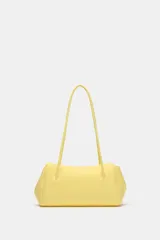 Bolso de hombro en formato alargado color amarillo pastel, con doble asa fina de hombro, bolsillo interior con cremallera y cierre imantado.