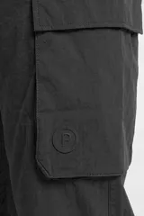 Pantalón cargo de nylon color beige, con elástico en la cintura y en los puños. Presenta bolsillos laterales con solapa y un logo de goma aplicado en uno de ellos.