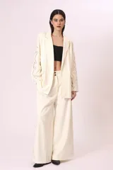 Pantalón palazzo color crudo con bordados florales en los laterales.