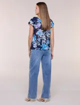 Blusa de gasa semitransparente color azul marino con estampado floral en tonos celestes y lilas, cuello redondo elastizado con lazo central y mangas cortas con doble volado.