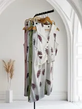 Conjunto blanco con estampado de hojas color borgoña, compuesto por un chaleco con botones y un pantalón de corte recto.