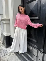 Sweater color crema tejido con diseño en ochos y cuello redondo.