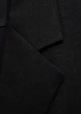 Chaleco tipo blazer sin mangas, de corte oversize y tejido de lino. Presenta cuello con solapas de muesca, bolsillos laterales de ribete y diseño abierto sin cierre.