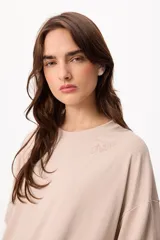 Remera de cuello redondo y manga corta con diseño holgado. Presenta un bordado sutil en el pecho con la palabra 'Petria'.