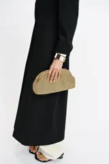 Bolso tipo sobre con acabado metalizado y diseño trenzado. Cuenta con una correa de cadena dorada extraíble, cierre mediante clip imantado y un bolsillo interior.