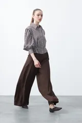 Pantalón ancho (wide leg) de color marrón oscuro, con calce fluido y lazo regulable en la cintura.