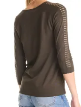 Buzo de tejido fino en color blanco, con cuello redondo y mangas raglán tres cuartos. Presenta una línea de tachas decorativas a lo largo de las mangas.