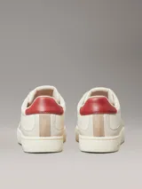 Zapatillas urbanas Calvin Klein Jeans de cuero color blanco con detalles en gamuza color beige y talón en cuero color rojo. Presentan logo de la marca grabado en el lateral y suela de goma.