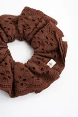 Scrunchie de algodón con diseño de broderie en color marrón.