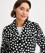 Bata corta de fleece color negro con estampado de lunares blancos, cuello solapa y lazo en la cintura.