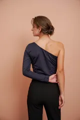 Top corto negro de un hombro con manga larga ajustada.