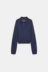 Polo de punto liso color azul marino, con cuello polo, manga larga y botones frontales.