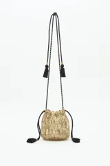 Cartera tipo saco de tamaño pequeño, confeccionada con tejido brillante en color dorado. Presenta cierre mediante cordones ajustables con borlas negras en los extremos y una correa larga de hombro con detalles decorativos y borlas adicionales.