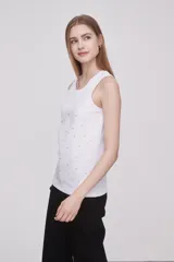 Musculosa blanca de algodón y elastano, con cuello redondo y detalle de strass aplicado en el frente. De corte al cuerpo y sin mangas.