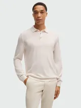 Polo de punto color crema, de corte slim-fit, manga larga y cuello polo con tres botones.