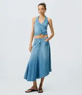 Pollera midi de jean color azul, con cintura baja, diseño asimétrico y ruedo irregular.