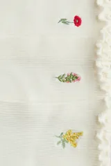 Pack de tres pares de medias de punto acanalado color blanco, con borde superior elástico y ribete sobrehilado. Cada par presenta un delicado bordado floral diferente.