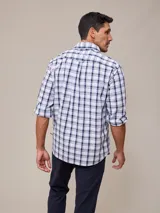 Camisa de manga larga para hombre, confeccionada en algodón con efecto peach (textura suave). Presenta un estampado de cuadros vichy en tonos azul marino y blanco, cuello con botones y un bolsillo de parche en el pecho izquierdo.
