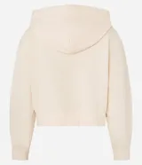 Saco color crema, de corte slim, confeccionado en algodón con viscosa certificada, con cuello con capucha y cordón ajustable, cierre frontal con cremallera y forro de fleece.