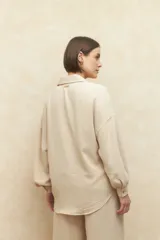 Camisa beige de manga larga con botones a tono.