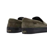 Championes Vans modelo Skate en colaboración con Beatrice Domond, de estilo mocasín slip-on. Confeccionados en gamuza color verde oliva, cuentan con suela de goma vulcanizada negra y detalle de etiqueta lateral a cuadros.
