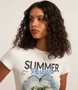 Remera de algodón color crudo, de corte ajustado, cuello redondo y manga corta. Estampado frontal con la frase "Summer Paradise" y un diseño floral.