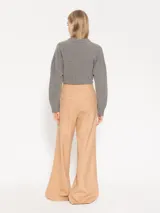 Pantalón de vestir color beige, de corte palazzo, con cintura alta y pinzas frontales.