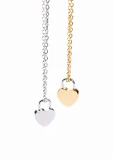 Set de dos collares de acero quirúrgico, uno plateado y otro dorado, con dije de candado en forma de corazón.
