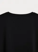Camiseta deportiva de manga corta en color bordó, con diseño de cuello redondo y paneles laterales con perforaciones para mayor ventilación. Presenta un pequeño logo reflectante en la parte inferior.