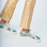 Zapatillas blancas con puntera y talón celeste brillante, laterales con estampado de piel de serpiente, estrella dorada en el lateral y cordones blancos.