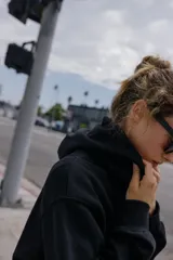 Sudadera de manga larga con capucha ajustable mediante cordones, bolsillo frontal tipo canguro y puños y ruedo en tejido rib.